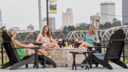 Women enjoying drinks by the fire pit