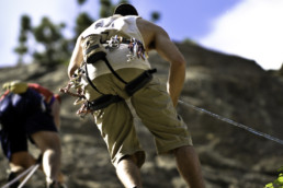 People repelling down a mountain