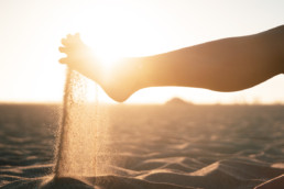 A person playing with sand with their feet