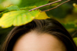 A female posing under some leaves